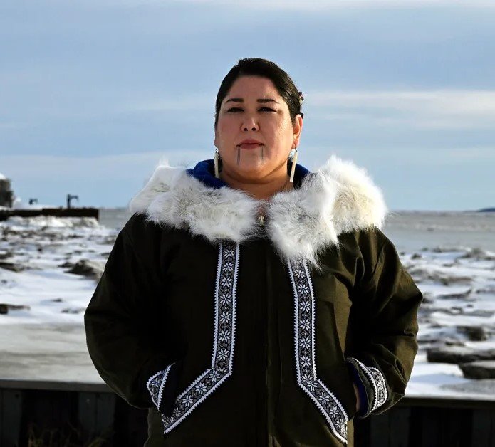 Alannah Acaq Hurley standing along the icy Bristol Bay shoreline in traditional Yupik attire