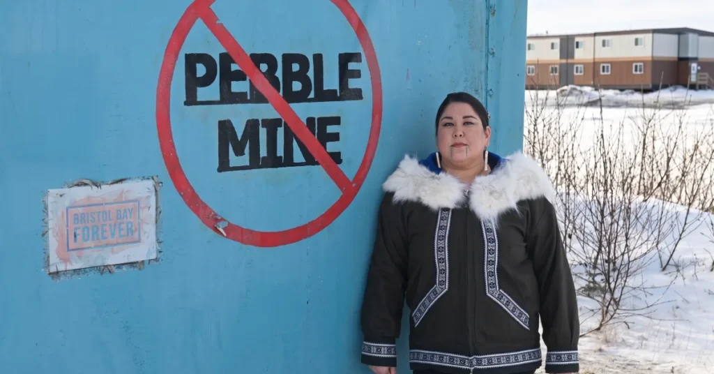 Alannah Hurley standing in front of a No Pebble Mine community mural in Alaska