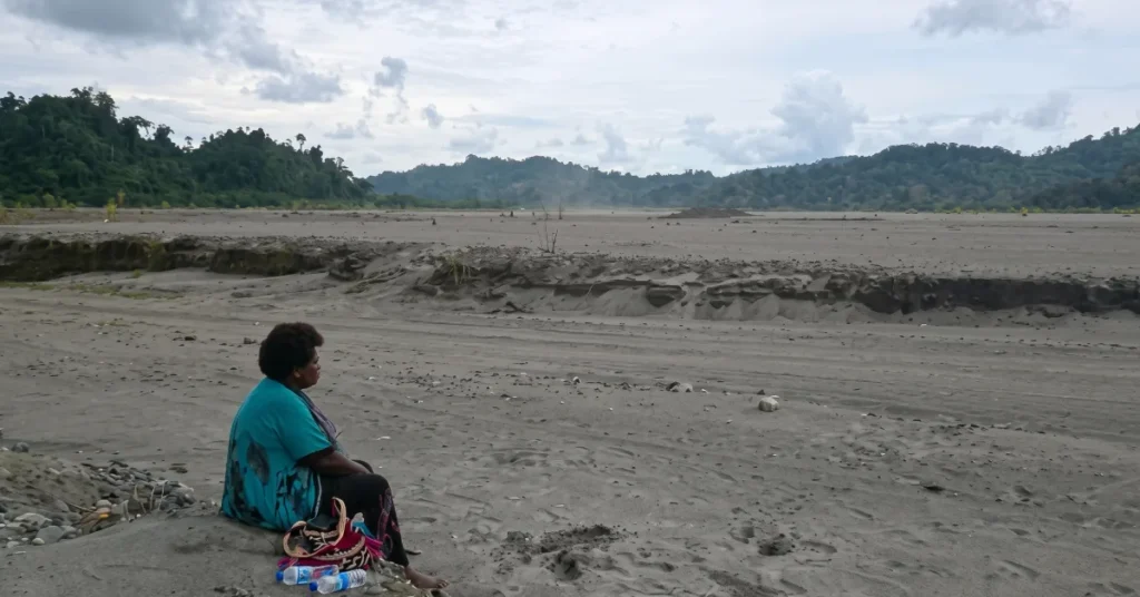 Theonila Roka Matbob sitting near the sediment-filled Kawerong-Jaba riverbed affected by Panguna mine waste