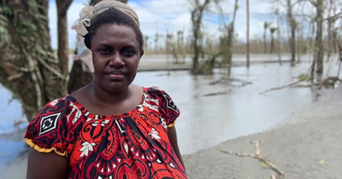 Theonila Roka Matbob standing near the flooded Kawerong-Jaba riverbed affected by Panguna mine waste in Bougainville