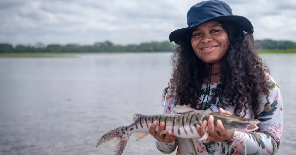 Yuvelis Morales Blanco holding a freshwater river fish supporting artisanal fishing livelihoods