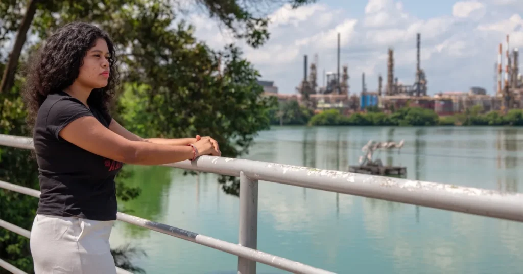 Yuvelis Morales Blanco overlooking an industrial oil refinery complex near Magdalena Medio waterways