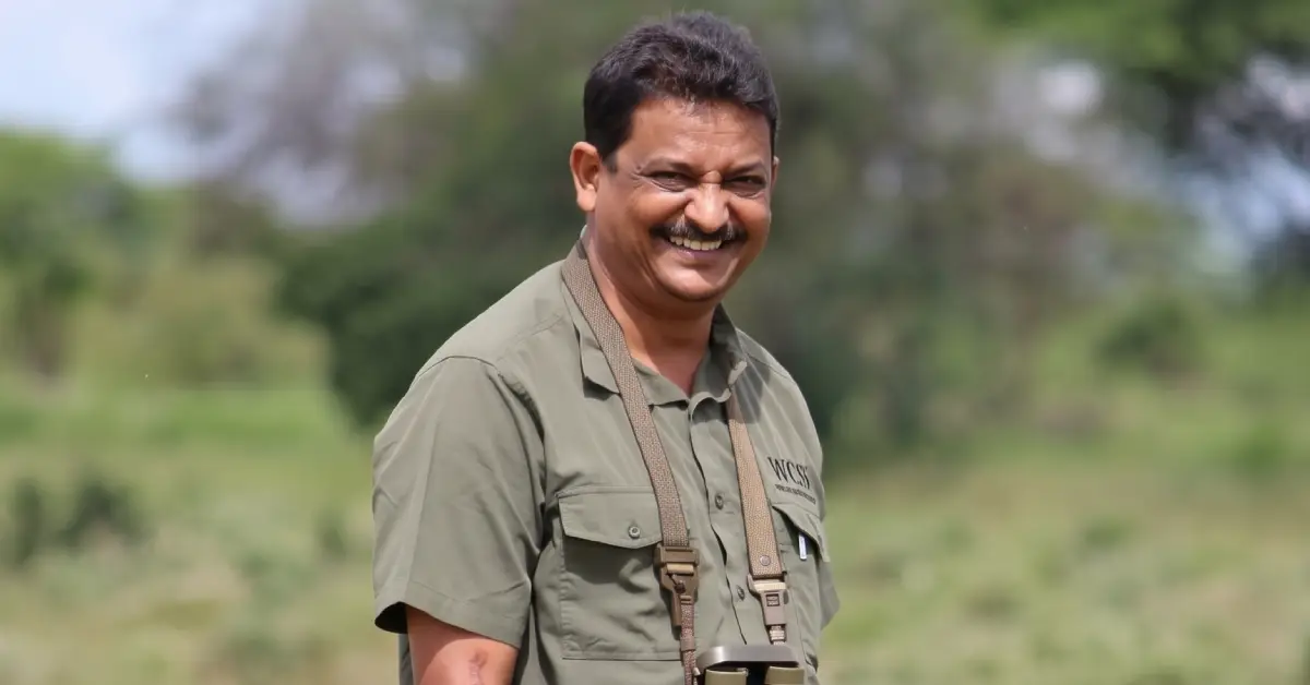 Wildlife biologist and conservationist Sanjay Gubbi standing outdoors in field gear with binoculars (3)